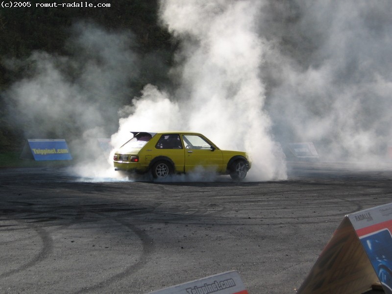 Yellow Toyota Starlet burning tires