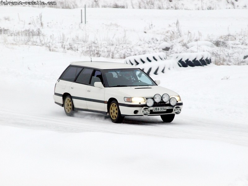 Valkoinen Subaru Legacy farmari lisävaloilla