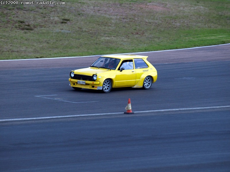 Yellow Toyota Starlet KP60 on race track